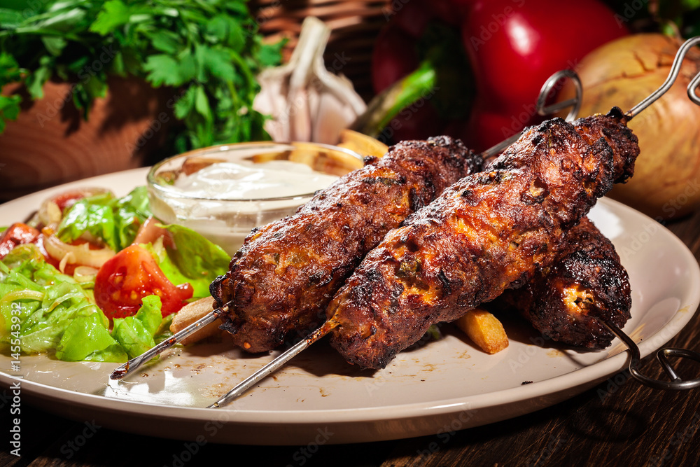 Grilled shish kebab served with fried chips and salad Grilled shish kebab served with fried chips and salad