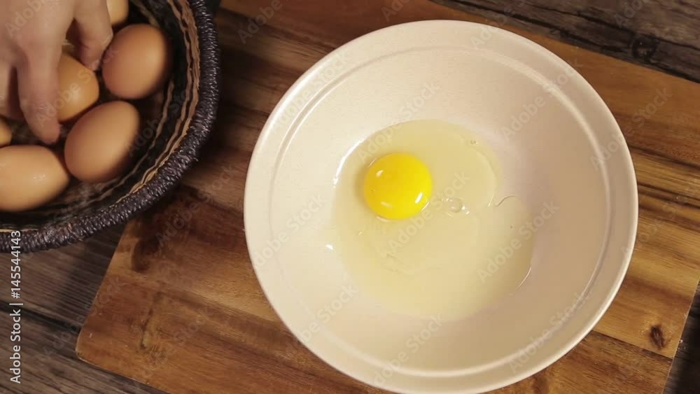 Eggs - Breaking 2 Brown Eggs In White Bowl - Top Angle Eggs - Breaking 2 Brown Eggs In White Bowl - Top Angle