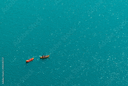 Unrecognizable people enjoying summer afternoon in boats on lake Bled