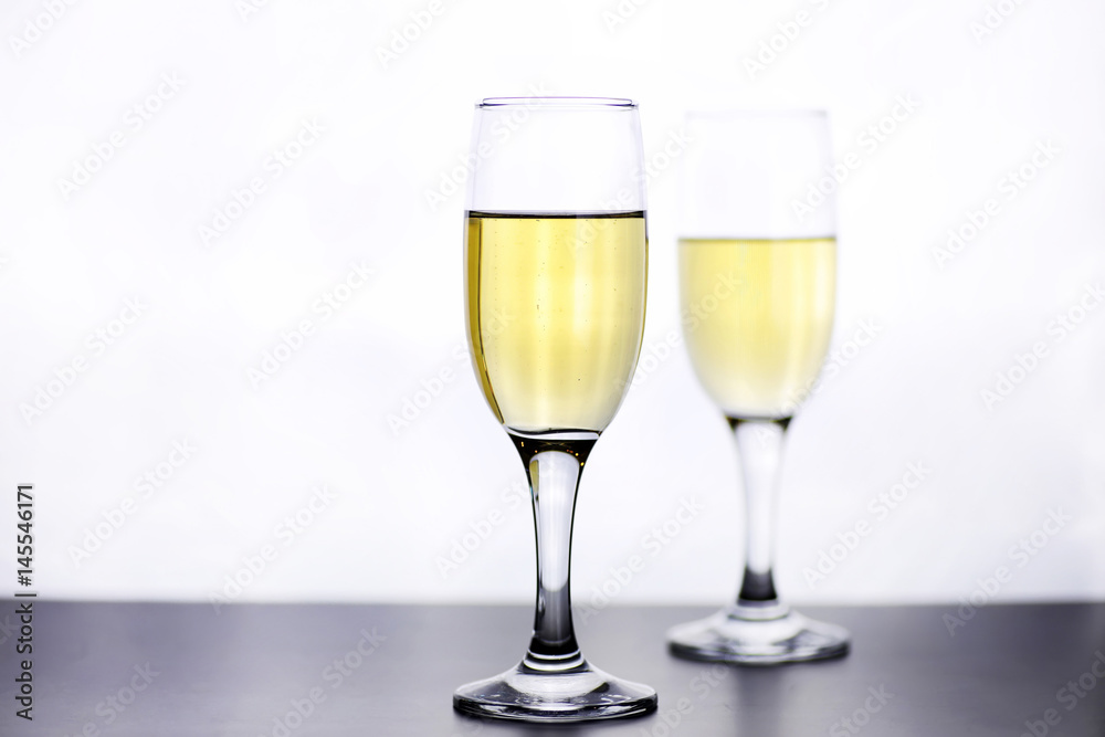 glass of white wine on a table on white background isolate glass of white wine on a table on white background isolate