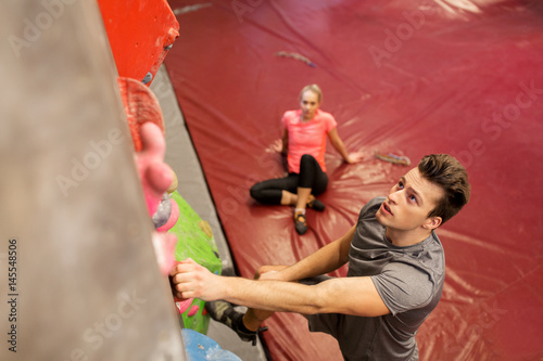man and woman exercising at indoor climbing gym