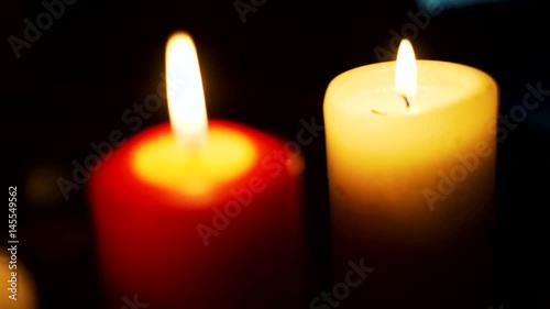 Three candles on table in empty dark room
