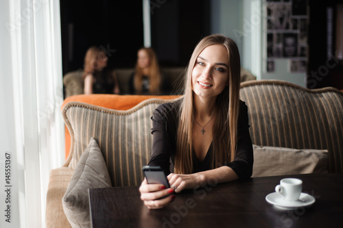 businesswoman talking on phone in a coffee shop