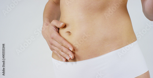 Beautiful body of a young girl showing off that she is in perfect ,on white background.Concept:diet,proper nutrition,sports body,slender body,work on yourself,love yourself,achieve,caring for the body