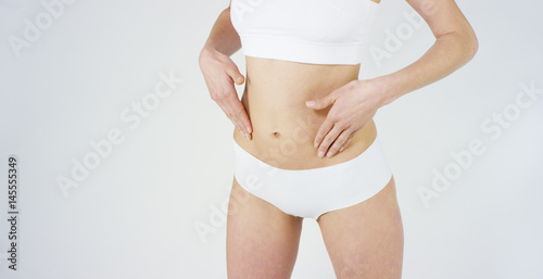 Beautiful body of a young girl showing off that she is in perfect ,on white background.Concept:diet,proper nutrition,sports body,slender body,work on yourself,love yourself,achieve,caring for the body