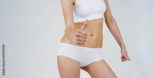 Beautiful body of a young girl showing off that she is in perfect ,on white background.Concept:diet,proper nutrition,sports body,slender body,work on yourself,love yourself,achieve,caring for the body © Kitreel