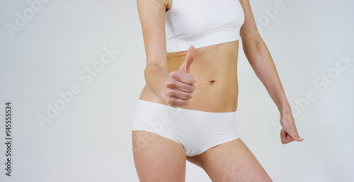 Beautiful body of a young girl showing off that she is in perfect ,on white background.Concept:diet,proper nutrition,sports body,slender body,work on yourself,love yourself,achieve,caring for the body