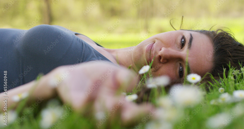 beautiful girl relaxing on sunset in a nice garden with daisy