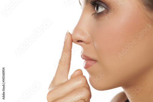 Profile of young woman touching her nose