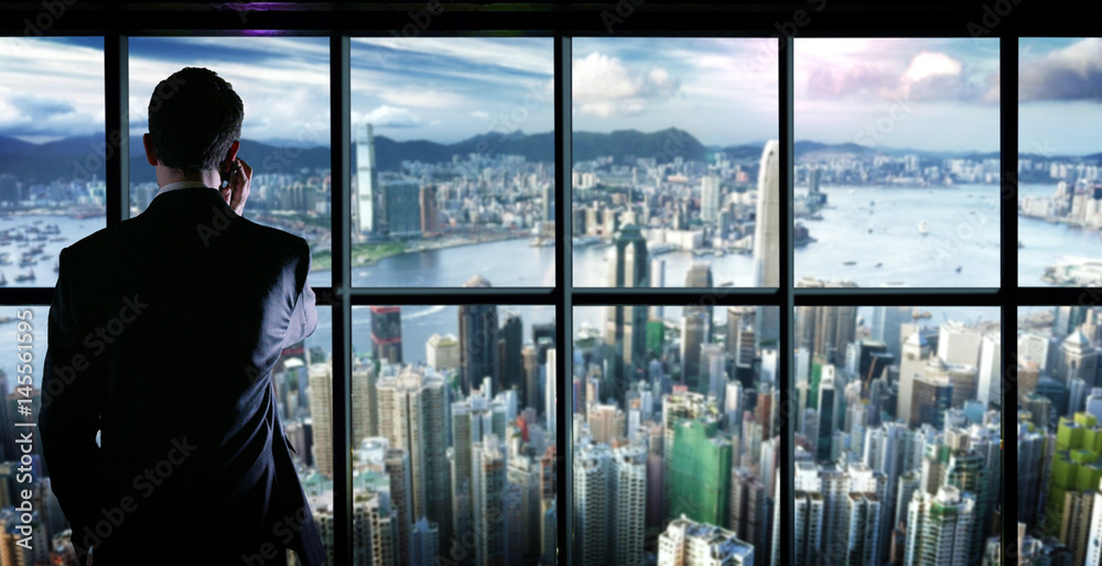 Fototapeta premium Business man in The top of a building answer to The phone a young business man on the type and Message phone or smart phone texting and writing . concept of the world access connections, connectivity