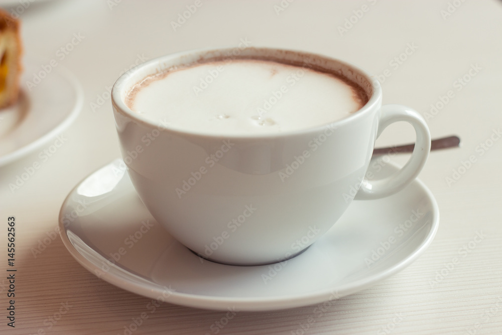 Large coffee mug. Hot chocolate and cheesecake on the table. Large coffee mug. Hot chocolate and cheesecake on the table.