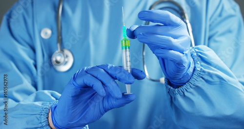 A doctor or scientist in laboratory holding a syringe with liquid vaccines for children or older adults, or cure animal diseases. Concept:diseases,medical care,science, anesthesia,euthanasia,diabetes.