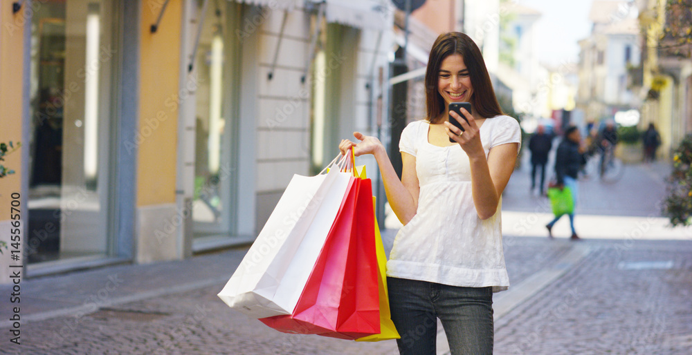 A beautiful woman sends a message after shopping, and is very happy of their purchases in the period balances. Concept: fashion, shopping, happiness and fashion bloggers. A beautiful woman sends a message after shopping, and is very happy of their purchases in the period balances. Concept: fashion, shopping, happiness and fashion bloggers.