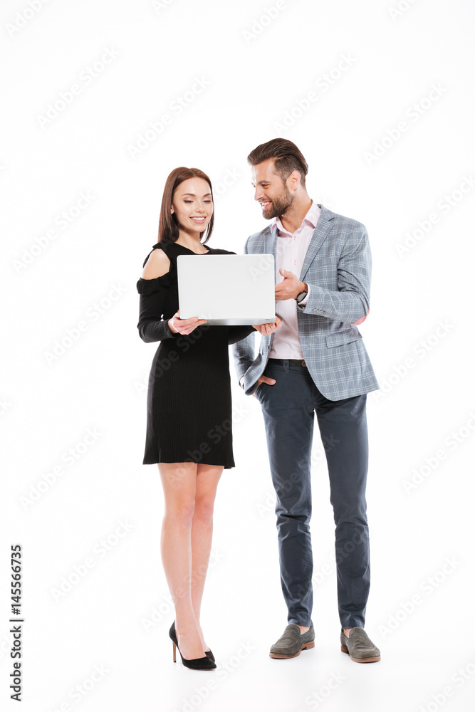 Cheerful young loving couple using laptop computer. Cheerful young loving couple using laptop computer.