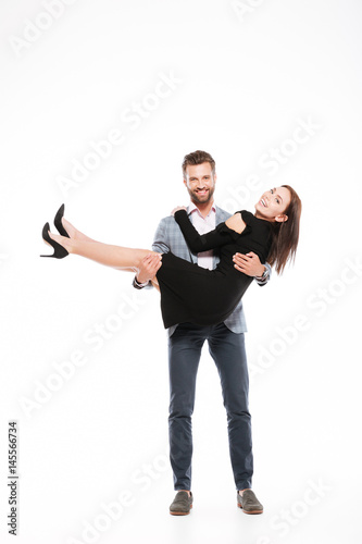 Happy young loving couple standing isolated