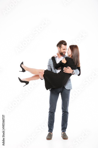 Smiling young loving couple standing isolated