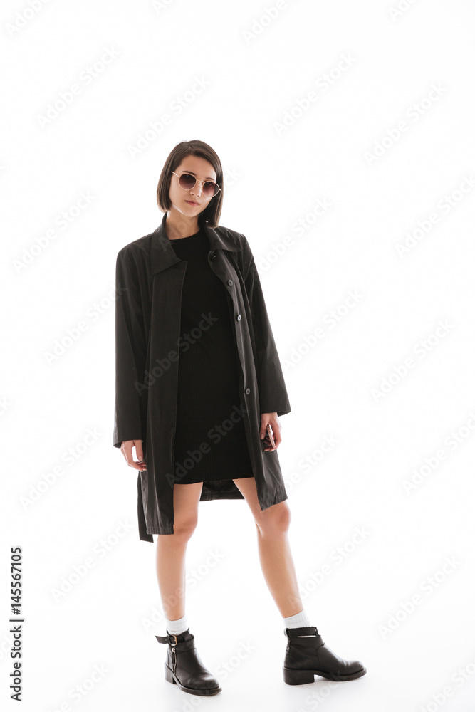 Serious young lady wearing sunglasses standing isolated Serious young lady wearing sunglasses standing isolated