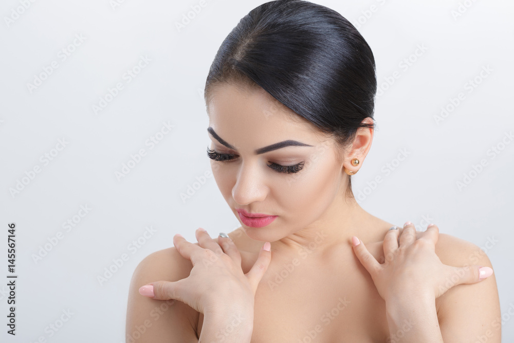Front portrait of attractive young brunette woman on grey background closeup. girl with clean skin Front portrait of attractive young brunette woman on grey background closeup. girl with clean skin