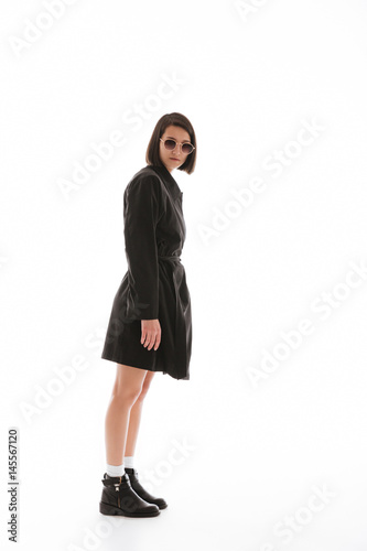 Serious young lady wearing sunglasses posing isolated