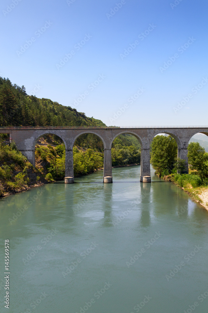 Fototapeta premium Bridge and river in the alps
