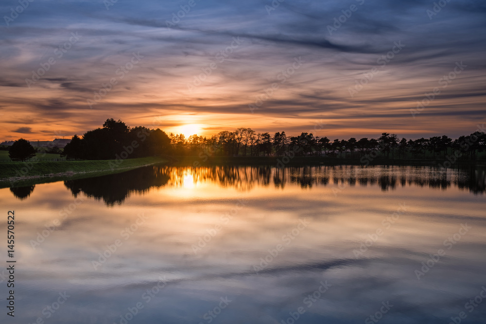 Sunset at Whittle Dene Reservoir / Whittle Dene Reservoir in Northumberland is a popular place for fishing, seen here as the sun goes down, reflecting the sky Sunset at Whittle Dene Reservoir / Whittle Dene Reservoir in Northumberland is a popular place for fishing, seen here as the sun goes down, reflecting the sky