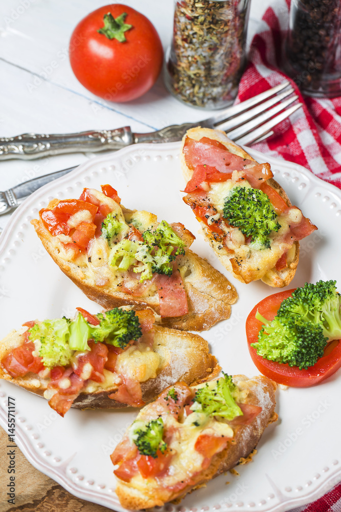 open sandwich with prosciutto, mozzarella and tomatoes on kitchen table, shallow focus open sandwich with prosciutto, mozzarella and tomatoes on kitchen table, shallow focus