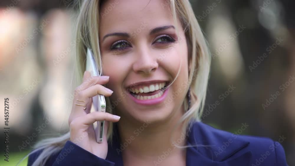 Close up on blond business woman talking on the phone smiling Close up on blond business woman talking on the phone smiling