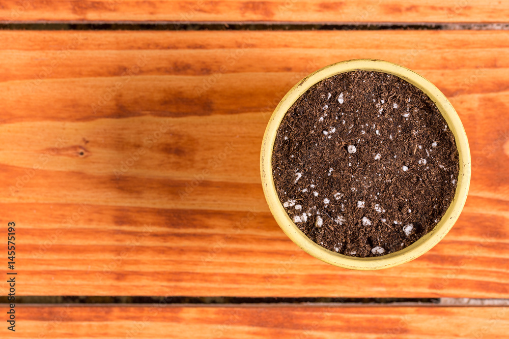 Flat lay above flower pot with soil for seeding plants Flat lay above flower pot with soil for seeding plants