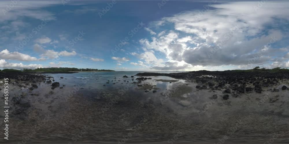 360 VR video. Timelapse shot of rippling ocean water, clouds sailing over the island and wind swinging the trees. View from the coast with black rocks 360 VR video. Timelapse shot of rippling ocean water, clouds sailing over the island and wind swinging the trees. View from the coast with black rocks