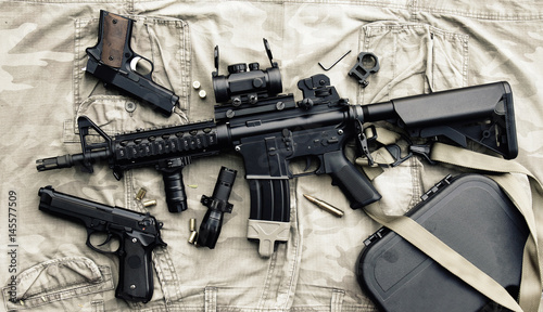 Weapons and military equipment for army, Assault rifle gun (M4A1) and pistol on camouflage background. photo