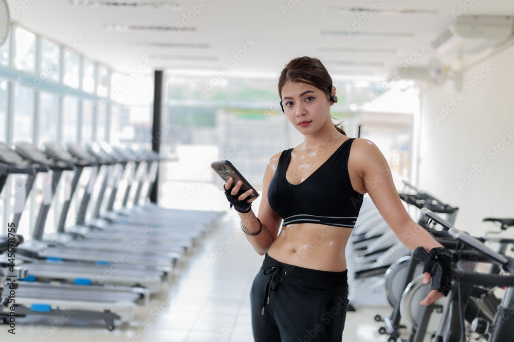 Asian athlete in sportswear fashion clothing. Sportswoman listening to  music using phone app for fitness activity tracker - heart rate monitor  tracking her health progress on smartphone. Stock Photo | Adobe Stock