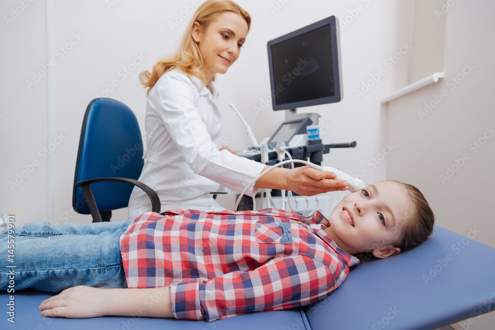 Fototapeta premium Delighted young practitioner providing ultrasound examination in the clinic