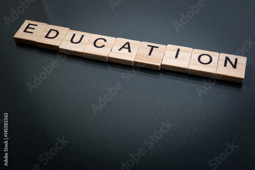 Wood block education word over backboard school. Education word formed by educational wood block. Education word concept for background.