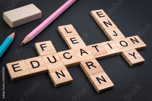 Wood block educaiton word over backboard school. Education word with pencil and eraser on black background. photo