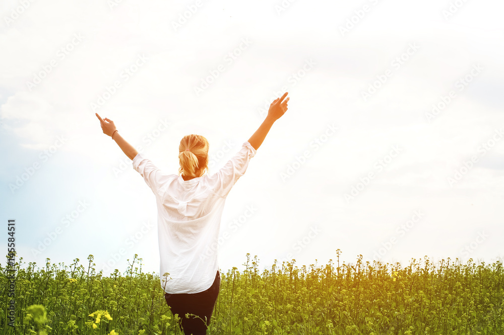 The beauty of a girl outdoors, enjoying nature and freedom and enjoying life. Beautiful girl in a white shirt, strolls on a spring field, the sun warm light. The beauty of a girl outdoors, enjoying nature and freedom and enjoying life. Beautiful girl in a white shirt, strolls on a spring field, the sun warm light.