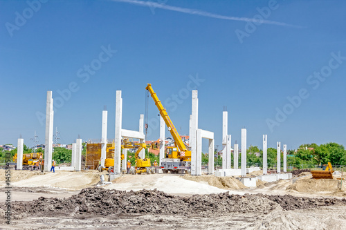 Concrete pillars of new edifice with a beautiful sky are placed on sandy ground