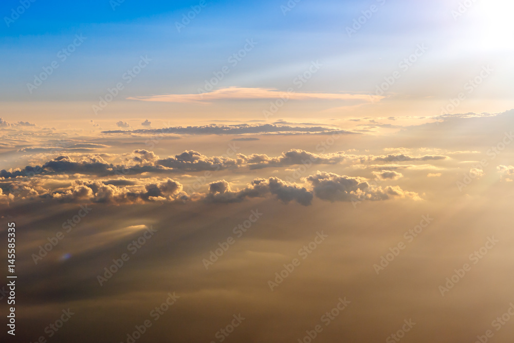 The colorful orange and blue soft sky above the clouds - airplane traveling in the summer