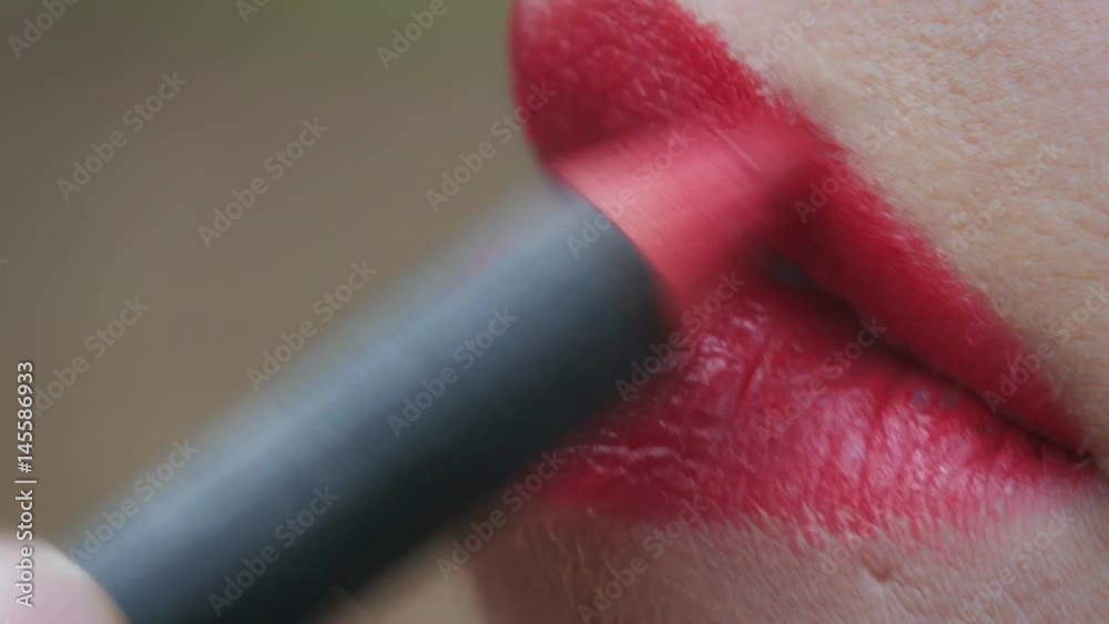 Applying red pencil to the lips- macro