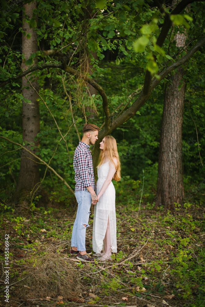 Beautiful Love story in the woods. Portrait of young stylish couple.