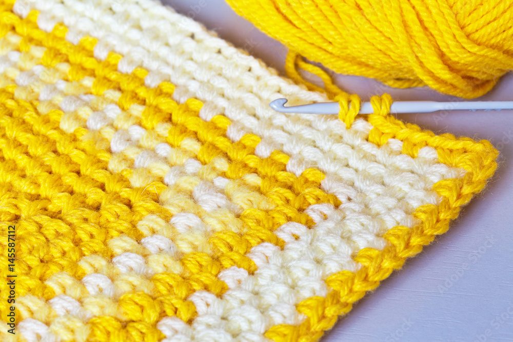 Needlework. Crochet from yellow acrylic yarn