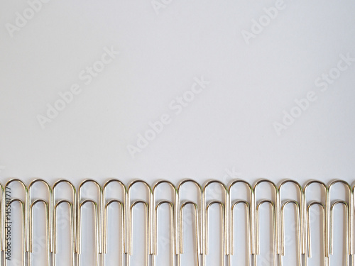 Silver paper clips on a white background with free text space.