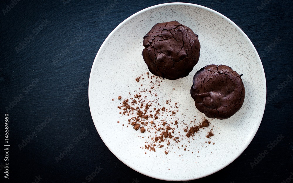 Chocolate muffins with nuts on dark background, selective focus Chocolate muffins with nuts on dark background, selective focus