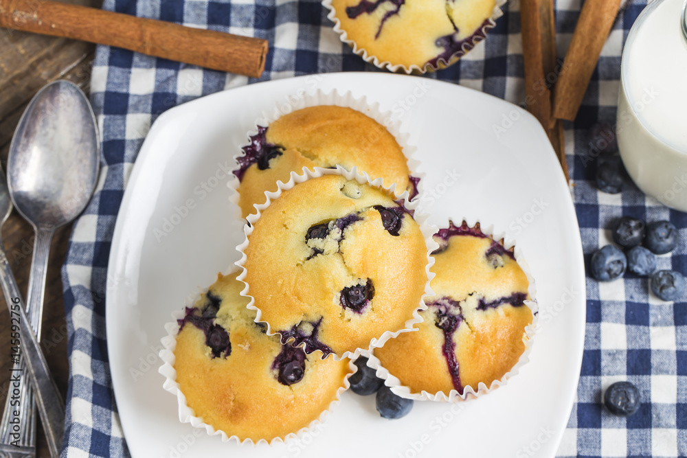Blueberry muffins with powdered sugar and fresh berries Blueberry muffins with powdered sugar and fresh berries