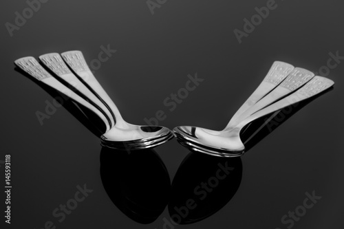 Six pieces of spoons on reflecting background