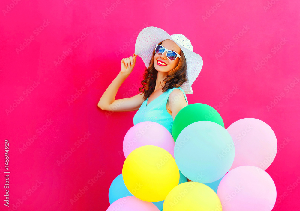 Fashion smiling young woman with an air colorful balloons is having fun on a pink background Fashion smiling young woman with an air colorful balloons is having fun on a pink background