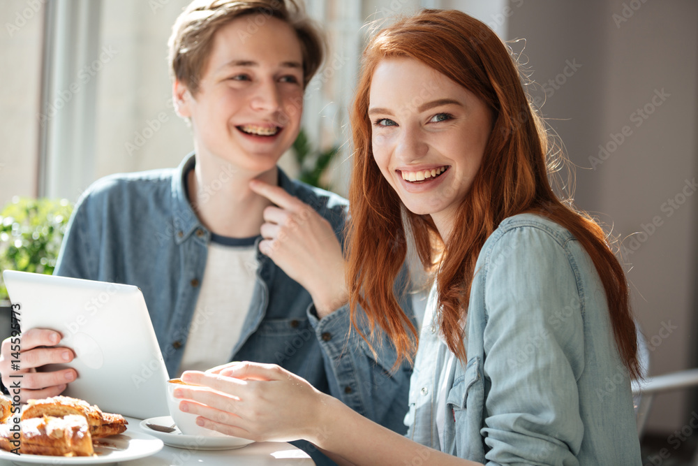 Redhead female student looking camera in cafe Redhead female student looking camera in cafe