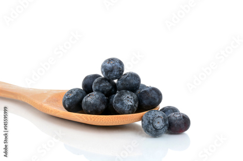 fresh blueberries on wooden spoon white background