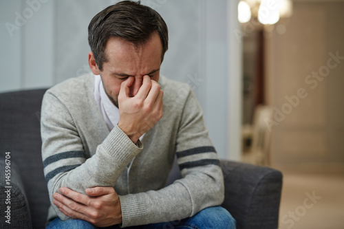 Desperate man crying during psychological session © pressmaster