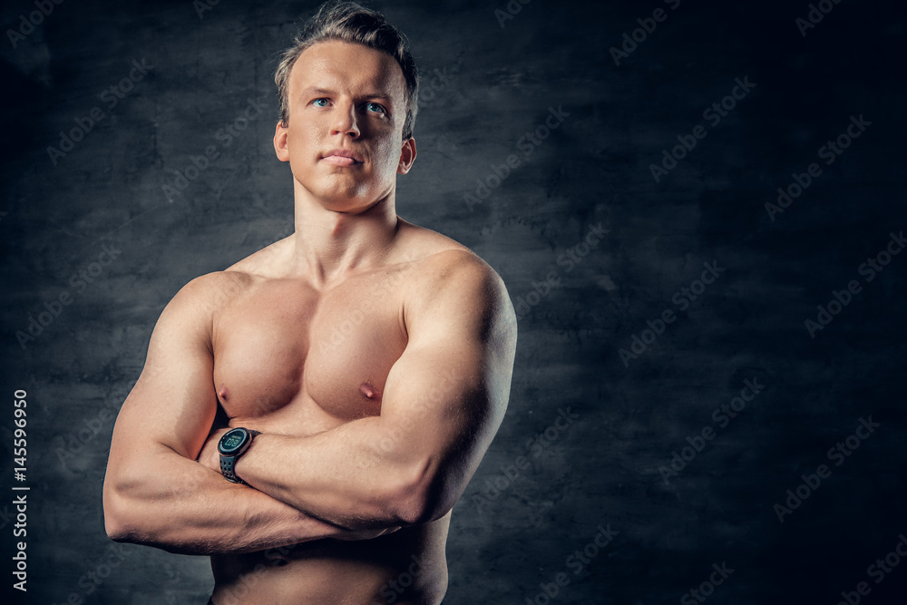 Obraz premium Studio portrait of shirtless athletic male with crossed arms.