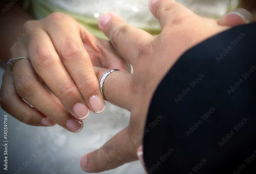 Close up hands of bride and groom putting on a wedding rings Close up hands of bride and groom putting on a wedding rings